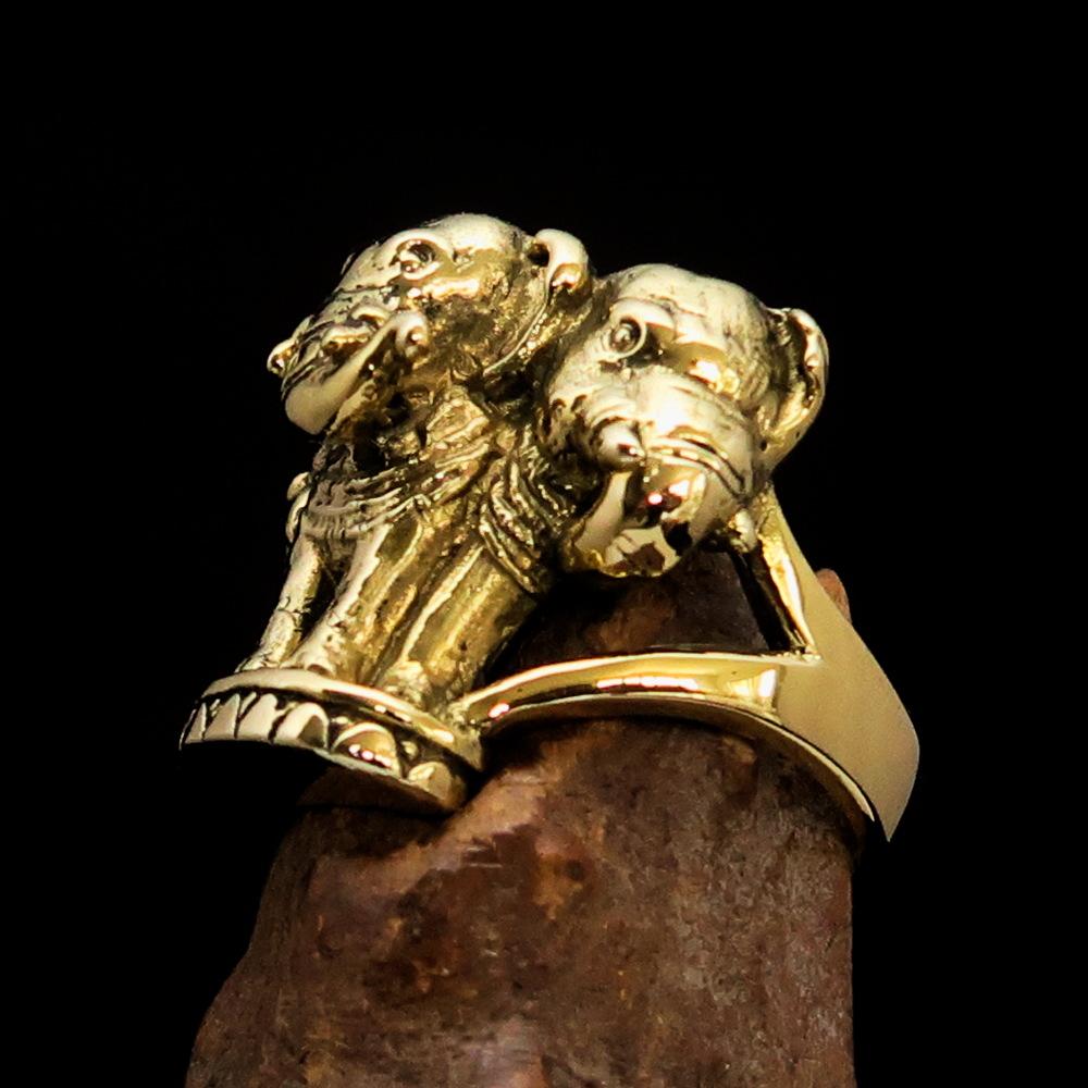 A stunning men's brass ring featuring an intricately designed three-headed elephant, showcasing its polished and antiqued finish.