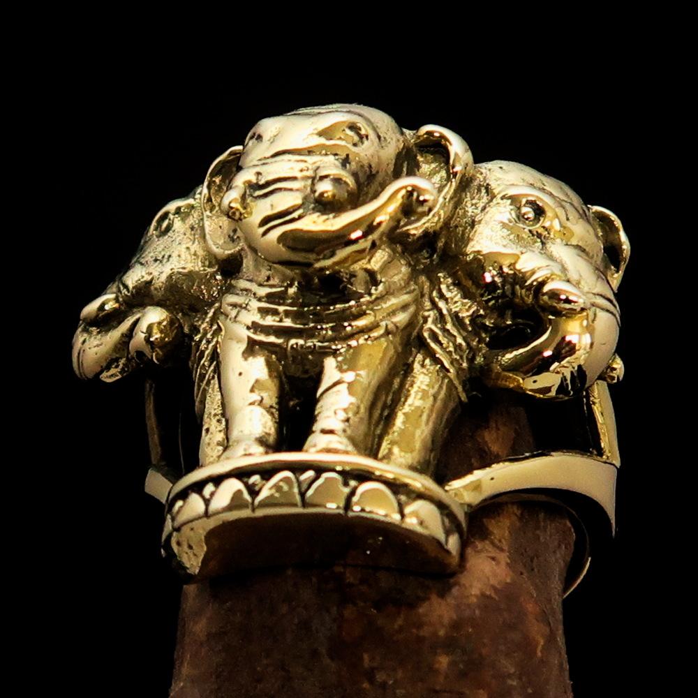 A stunning men's brass ring featuring an intricately designed three-headed elephant, showcasing its polished and antiqued finish.