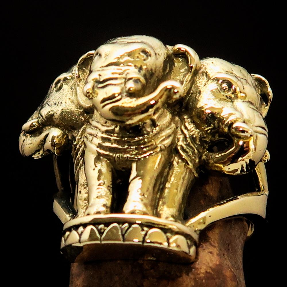 A stunning men's brass ring featuring an intricately designed three-headed elephant, showcasing its polished and antiqued finish.