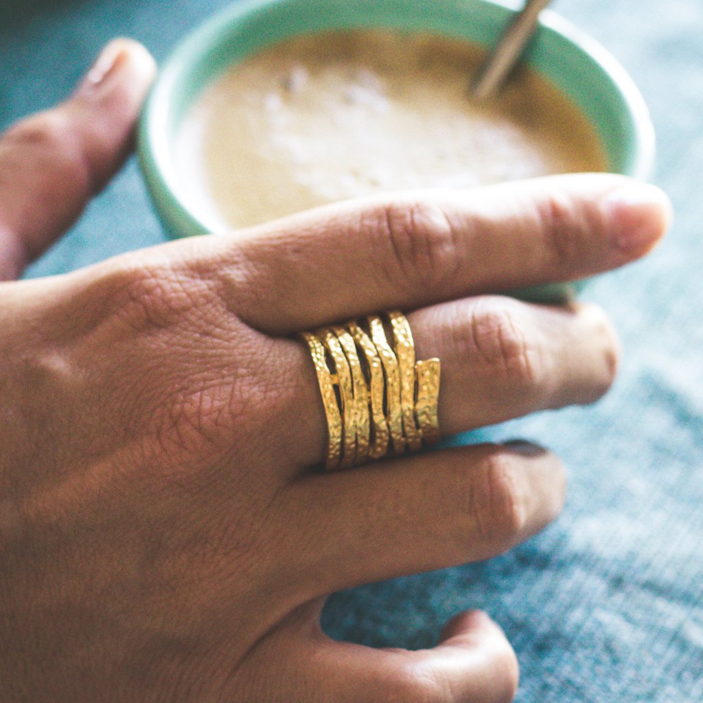 A stunning Swirling Ring featuring a unique spiral design, crafted from pewter with gold or silver plating, showcasing its artistic beauty.