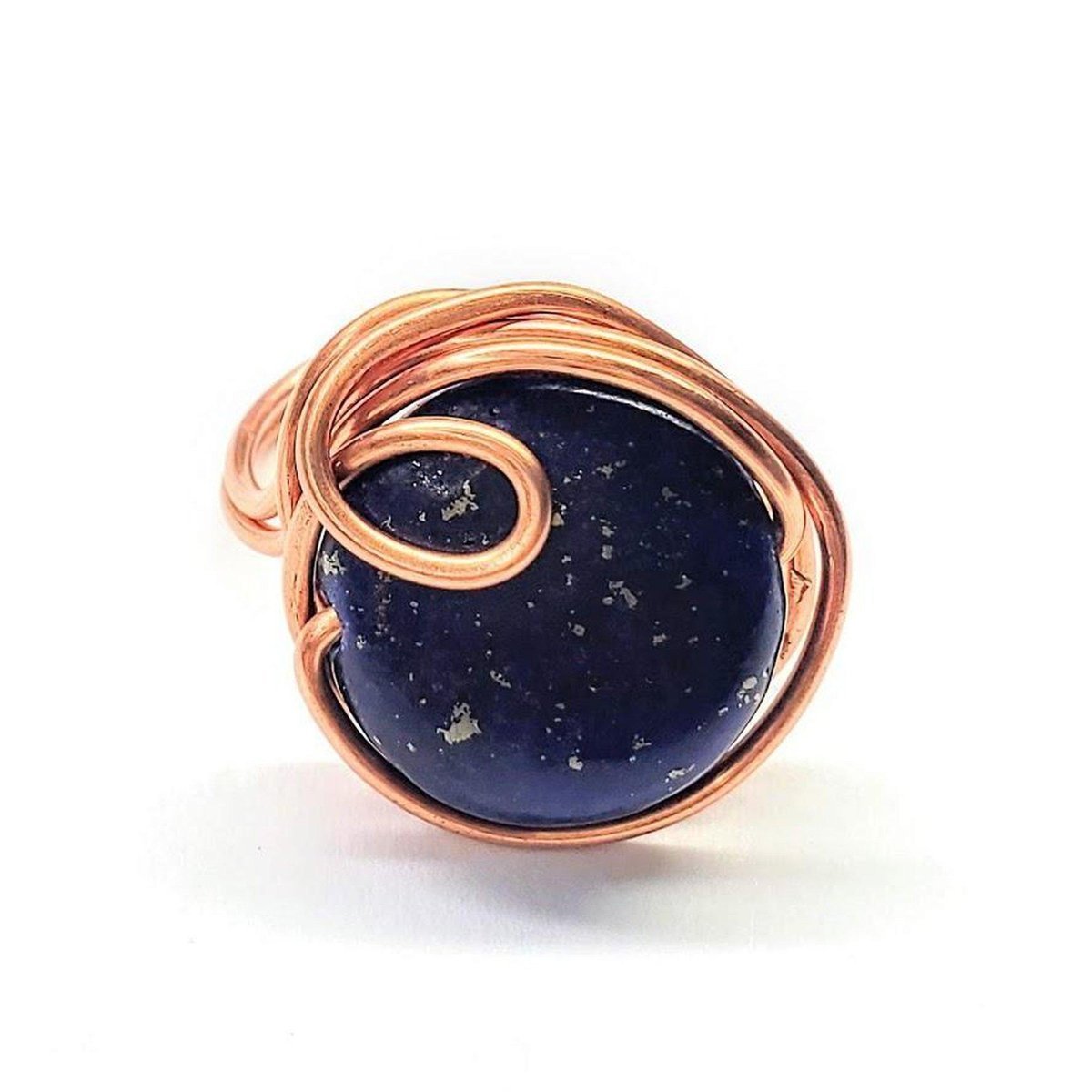 A handcrafted wire wrapped copper ring featuring a deep blue lapis lazuli coin bead, showcasing unique design and sparkling pyrite speckles.