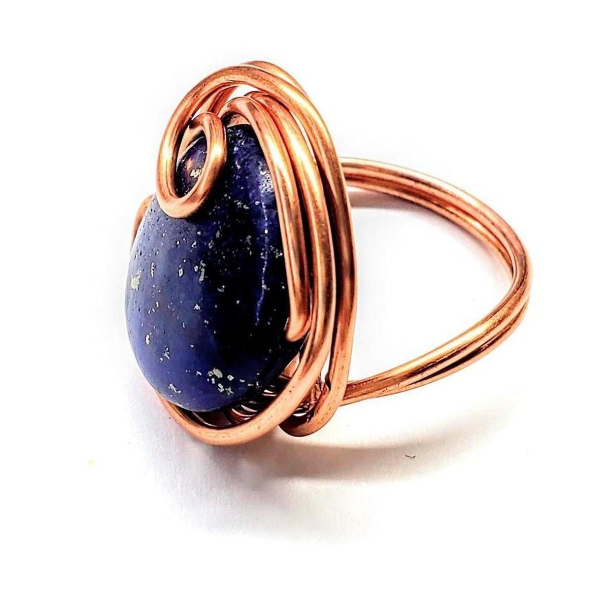 A handcrafted wire wrapped copper ring featuring a deep blue lapis lazuli coin bead, showcasing unique design and sparkling pyrite speckles.