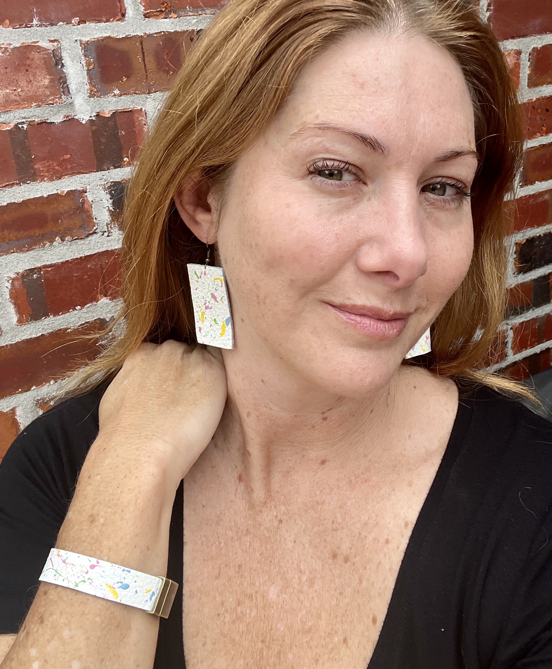 Woman wearing colorful splatter jewelry.