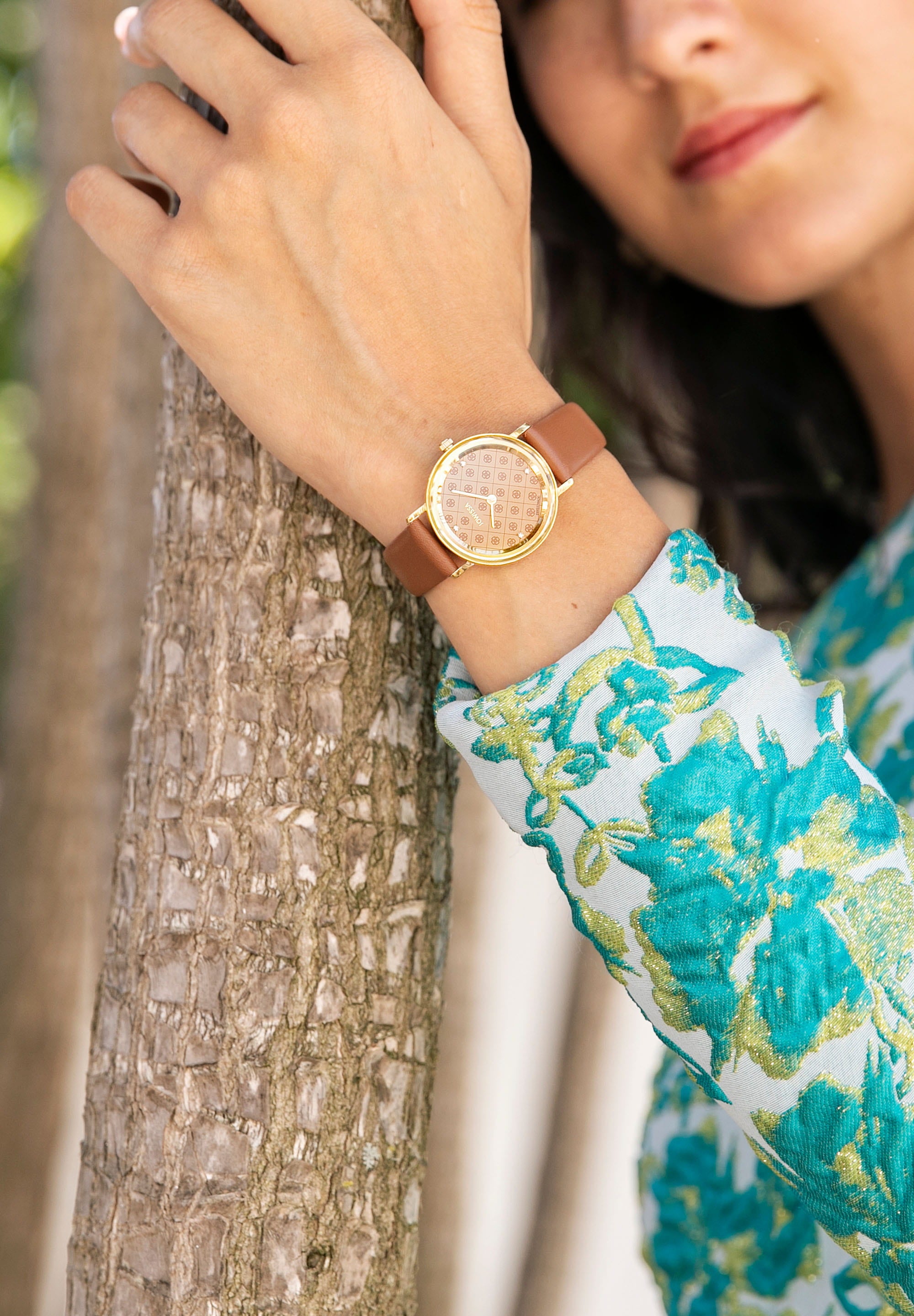 AnWy Swiss Ladies Watch J6.229.M featuring a logo-patterned dial, rhinestones, and a genuine leather strap in gold and brown.