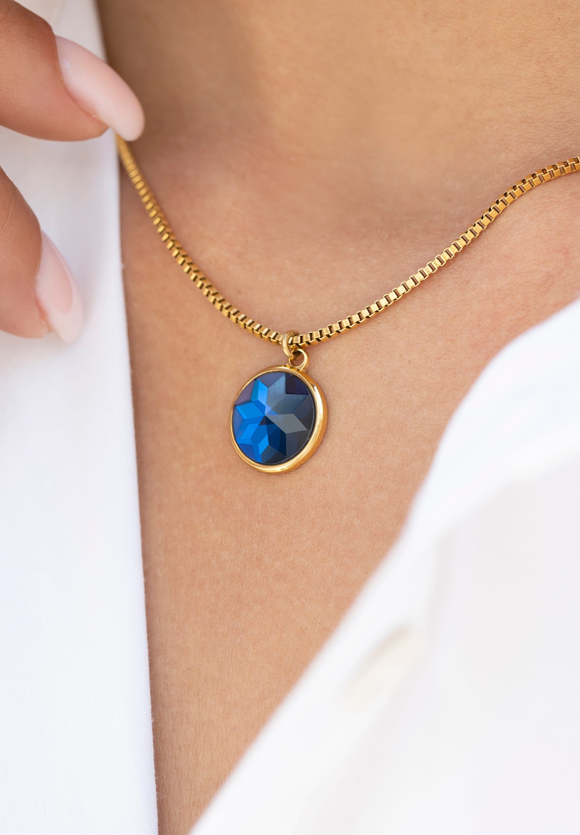 Facet Pendant Necklace JS.0005 featuring a blue faceted glass pendant on a gold plated stainless steel chain, elegantly displayed.