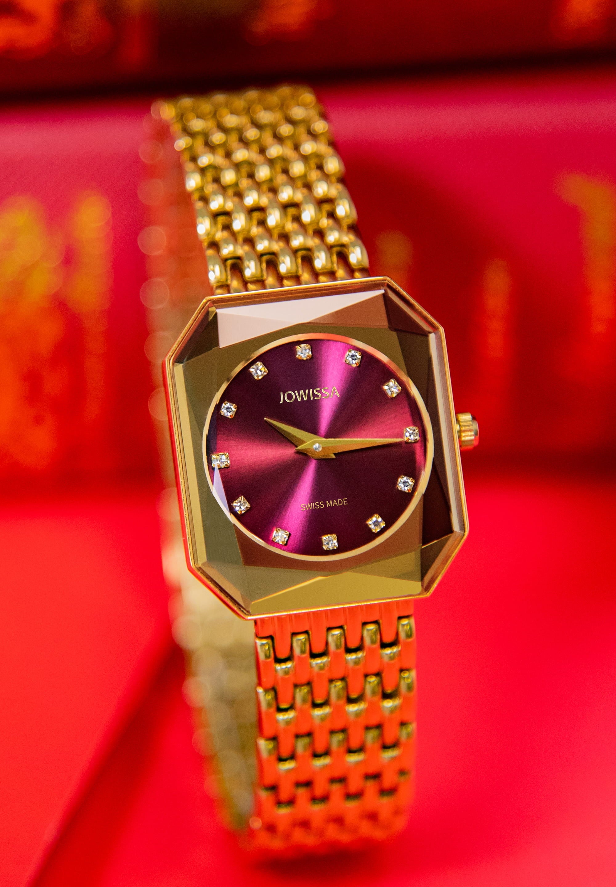 Facet Radiant Swiss Ladies Watch J8.082.M featuring a gold case and red dial with rhinestones.