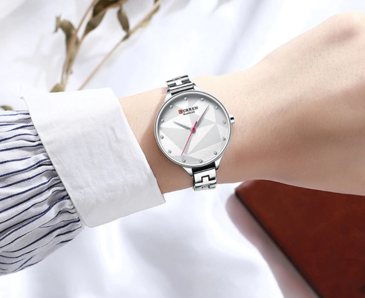 Scarlet Curren Women Watch featuring a round dial and sleek metal band, showcasing elegance and durability.