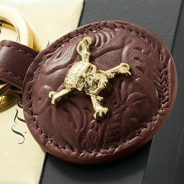 S.T. Dupont Pirates of the Caribbean embossed brown cowhide leather key ring featuring a gold skull and crossbones design.