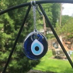 A beautifully crafted silver evil eye bead with a blue glass center and silver trim, perfect for decoration and protection.