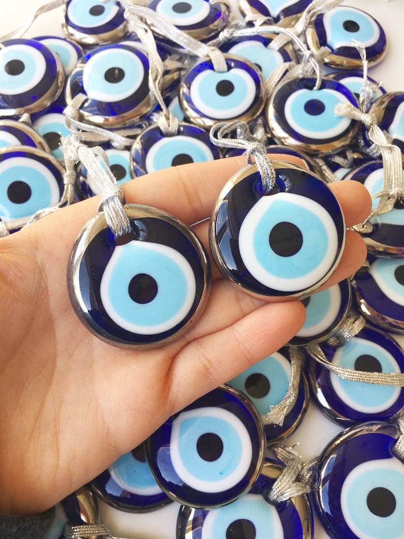 A beautifully crafted silver evil eye bead with a blue glass center and silver trim, perfect for decoration and protection.