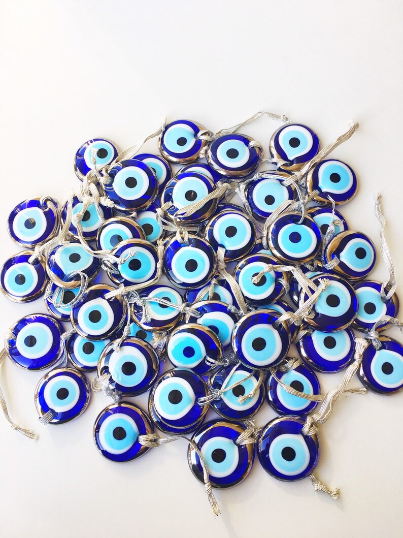 A beautifully crafted silver evil eye bead with a blue glass center and silver trim, perfect for decoration and protection.