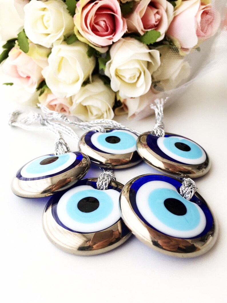 A beautifully crafted silver evil eye bead with a blue glass center and silver trim, perfect for decoration and protection.