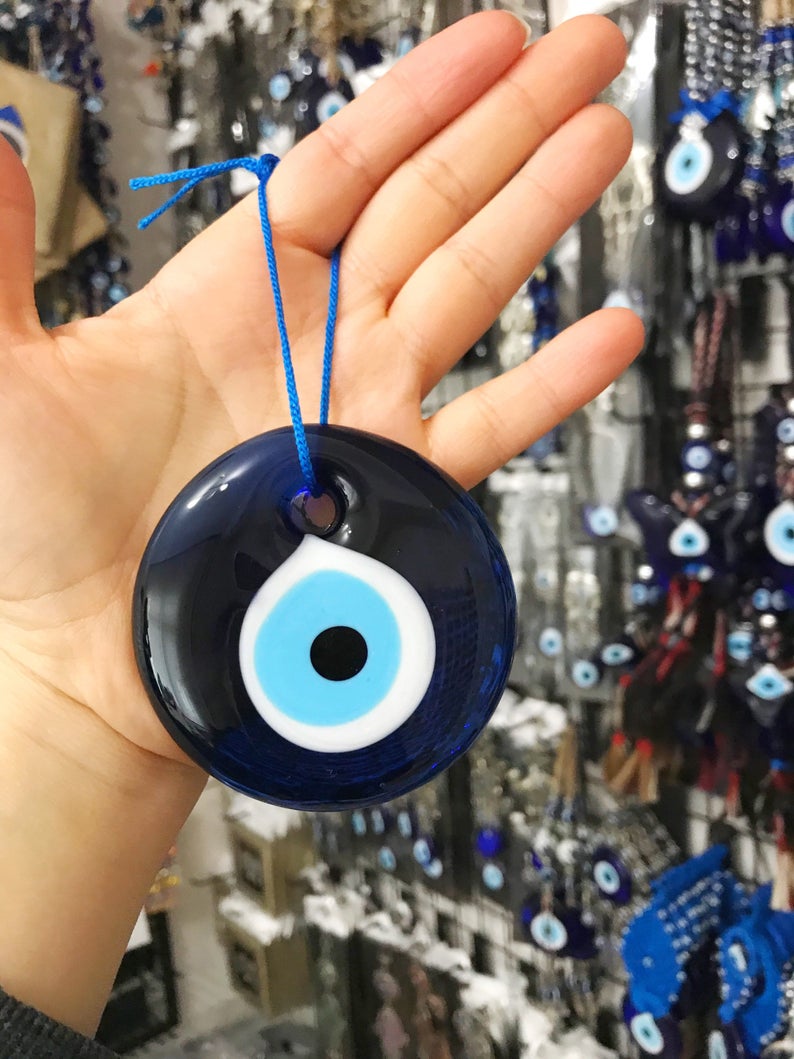 A 7cm handmade blue glass evil eye bead featuring intricate designs, symbolizing protection and good luck.