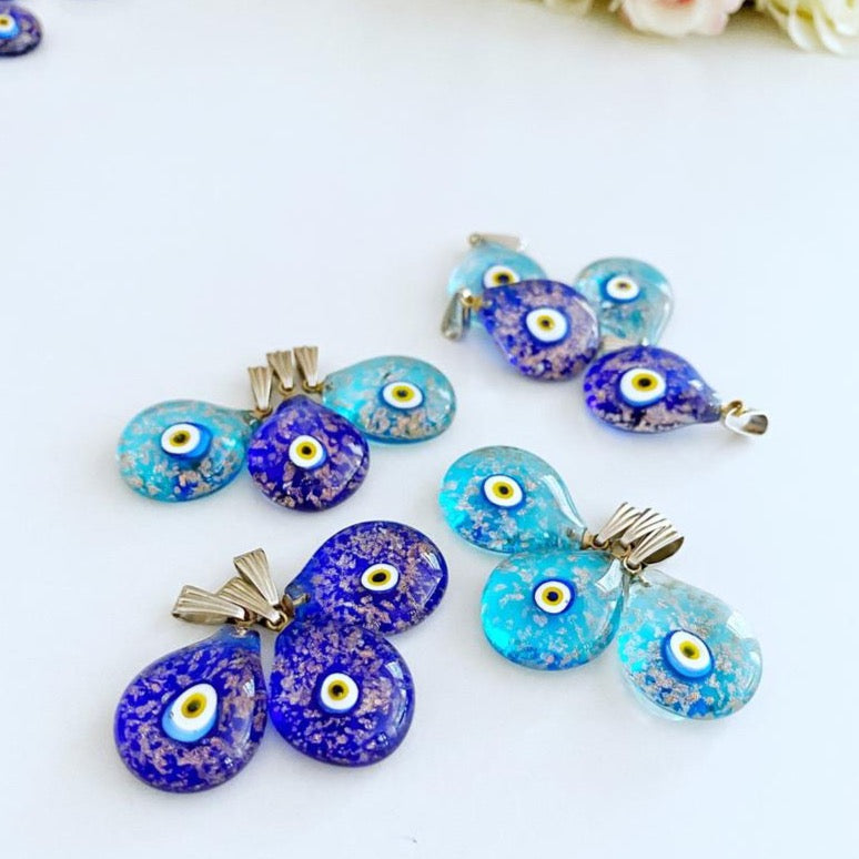 A collection of Handmade Murano Evil Eye Beads in blue and turquoise, showcasing intricate designs and vibrant colors.