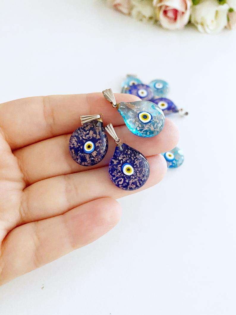 A collection of Handmade Murano Evil Eye Beads in blue and turquoise, showcasing intricate designs and vibrant colors.