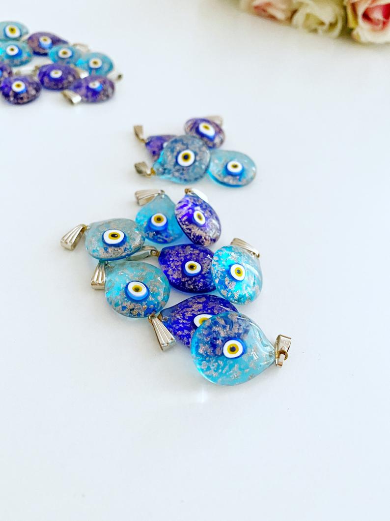 A collection of Handmade Murano Evil Eye Beads in blue and turquoise, showcasing intricate designs and vibrant colors.