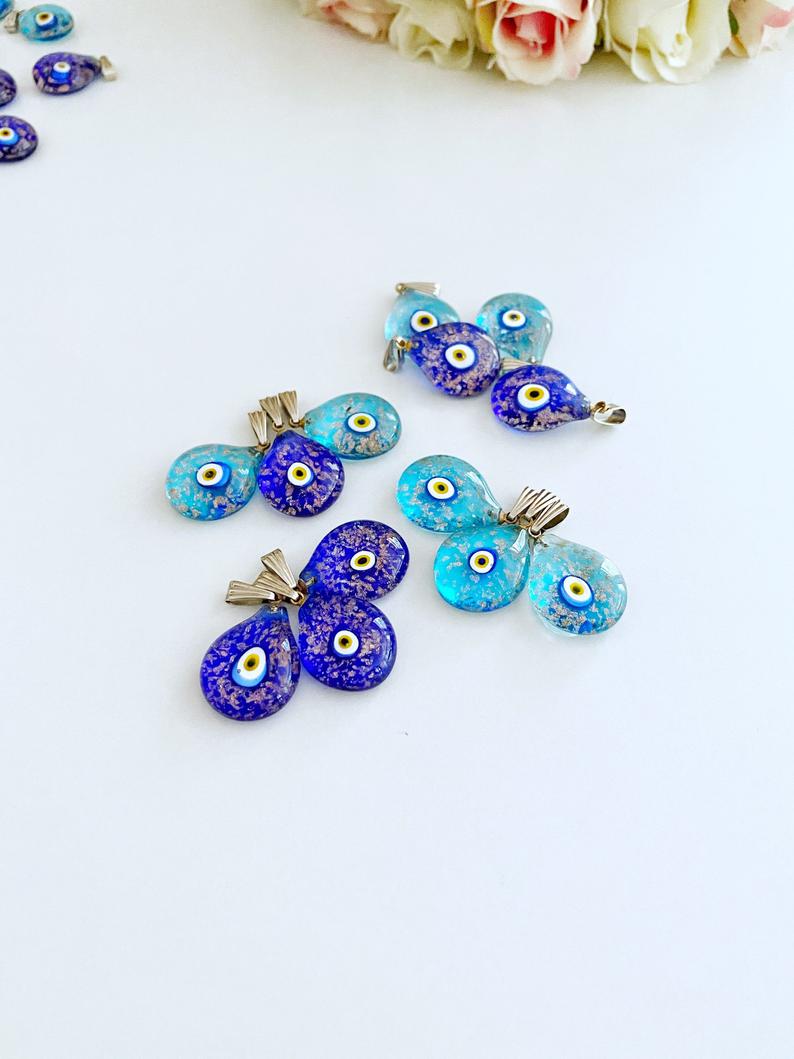 A collection of Handmade Murano Evil Eye Beads in blue and turquoise, showcasing intricate designs and vibrant colors.