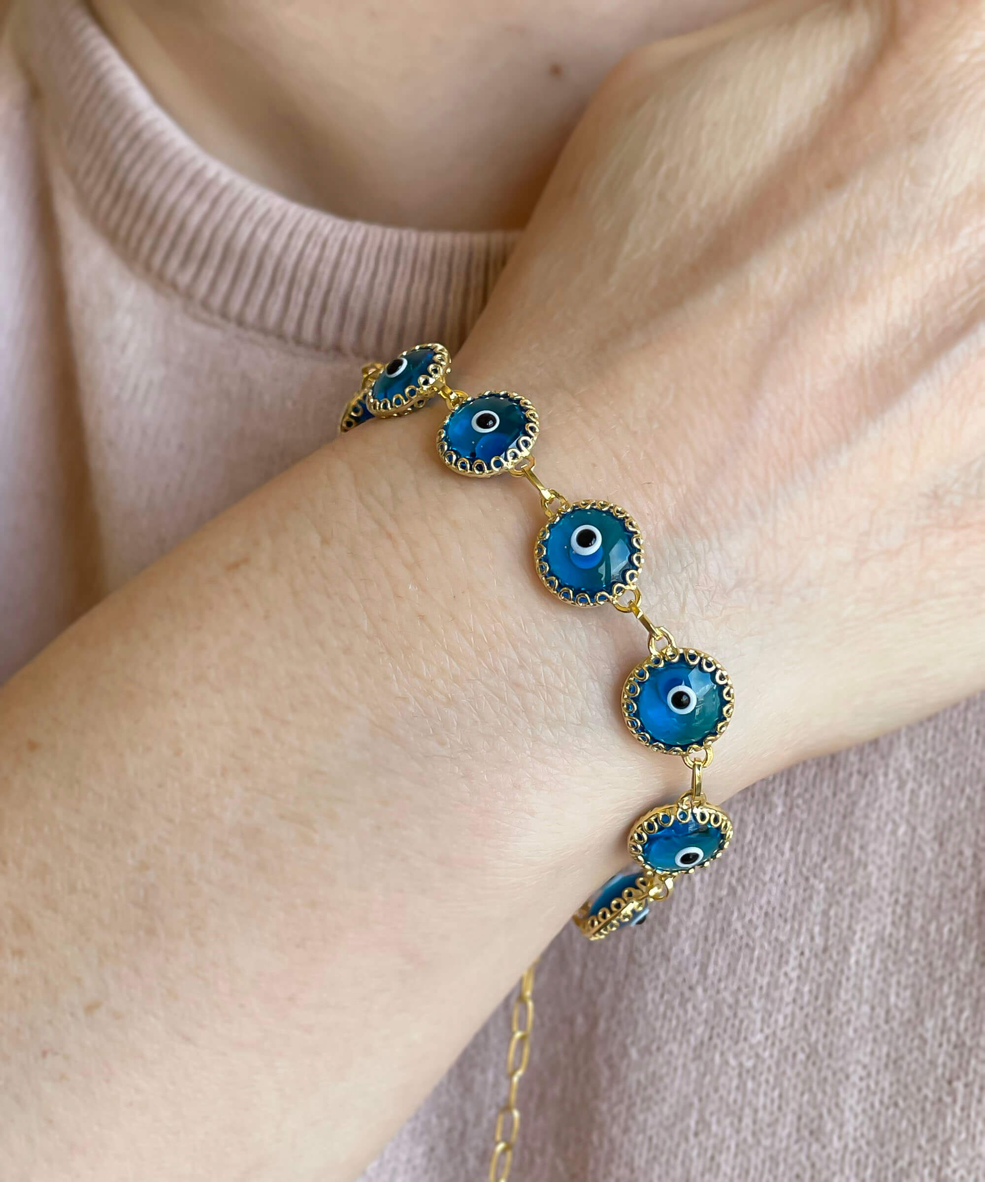 Gold plated sterling silver link bracelet featuring 10 lapis blue evil eye beads, elegantly designed with a lobster claw clasp.