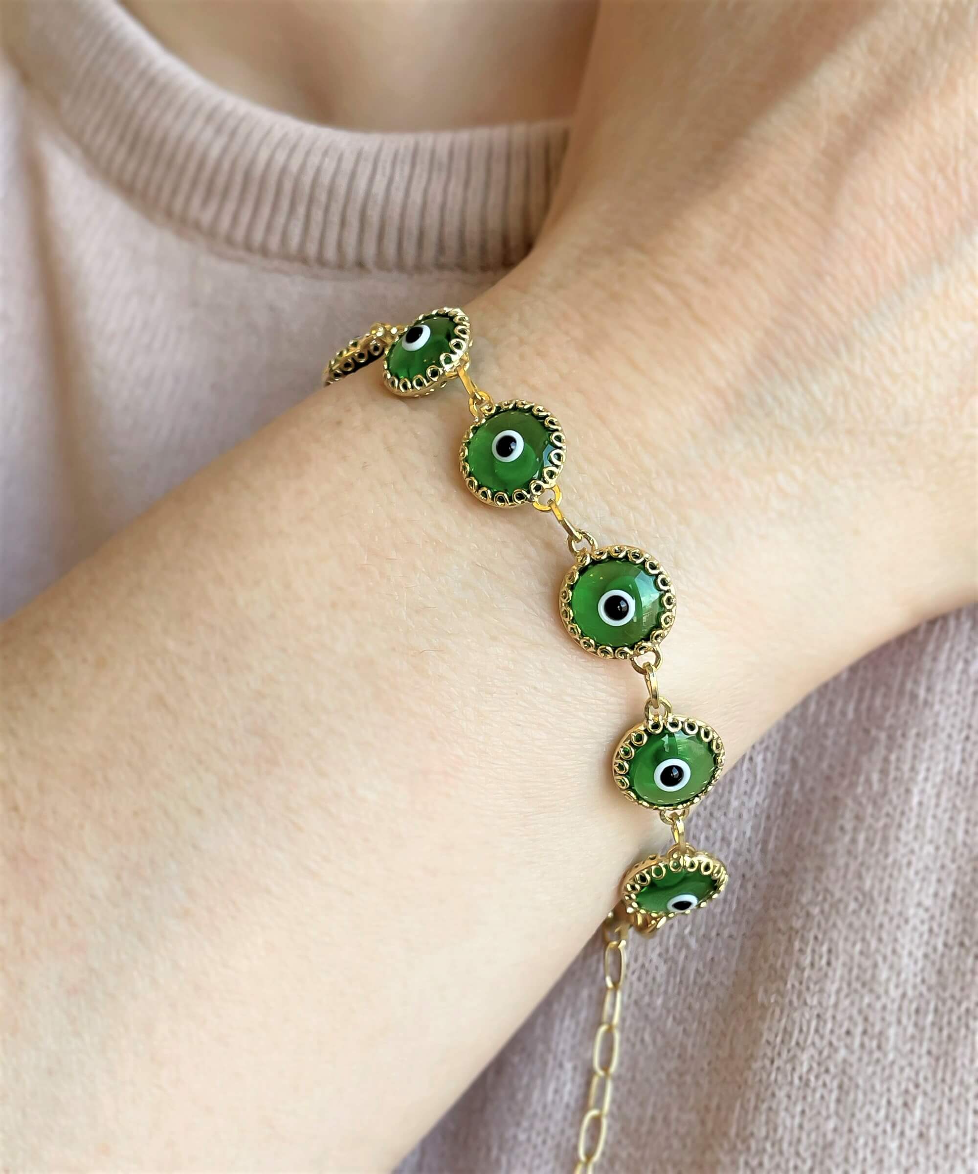 Mint green evil eye bracelet made of gold plated sterling silver with ten beads and a rolo chain design, secured with a lobster claw clasp.