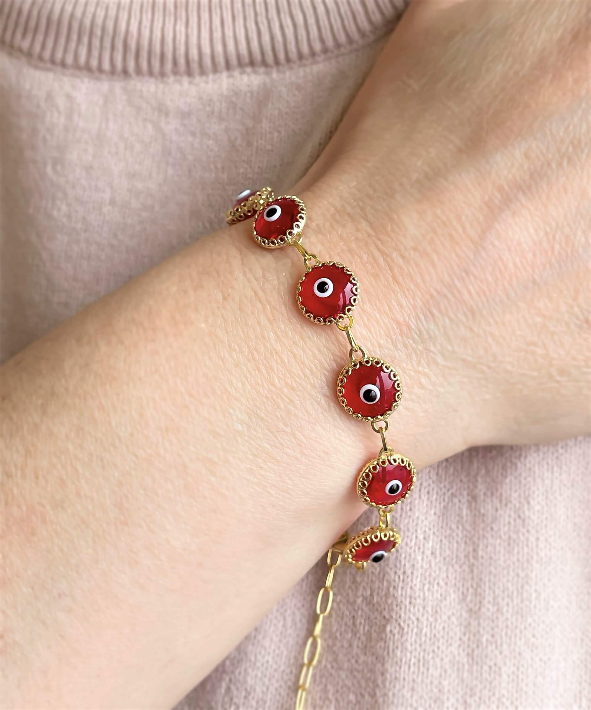 Gold plated sterling silver bracelet featuring 10 red evil eye beads, designed with a strong rolo chain and secured with a lobster claw clasp.