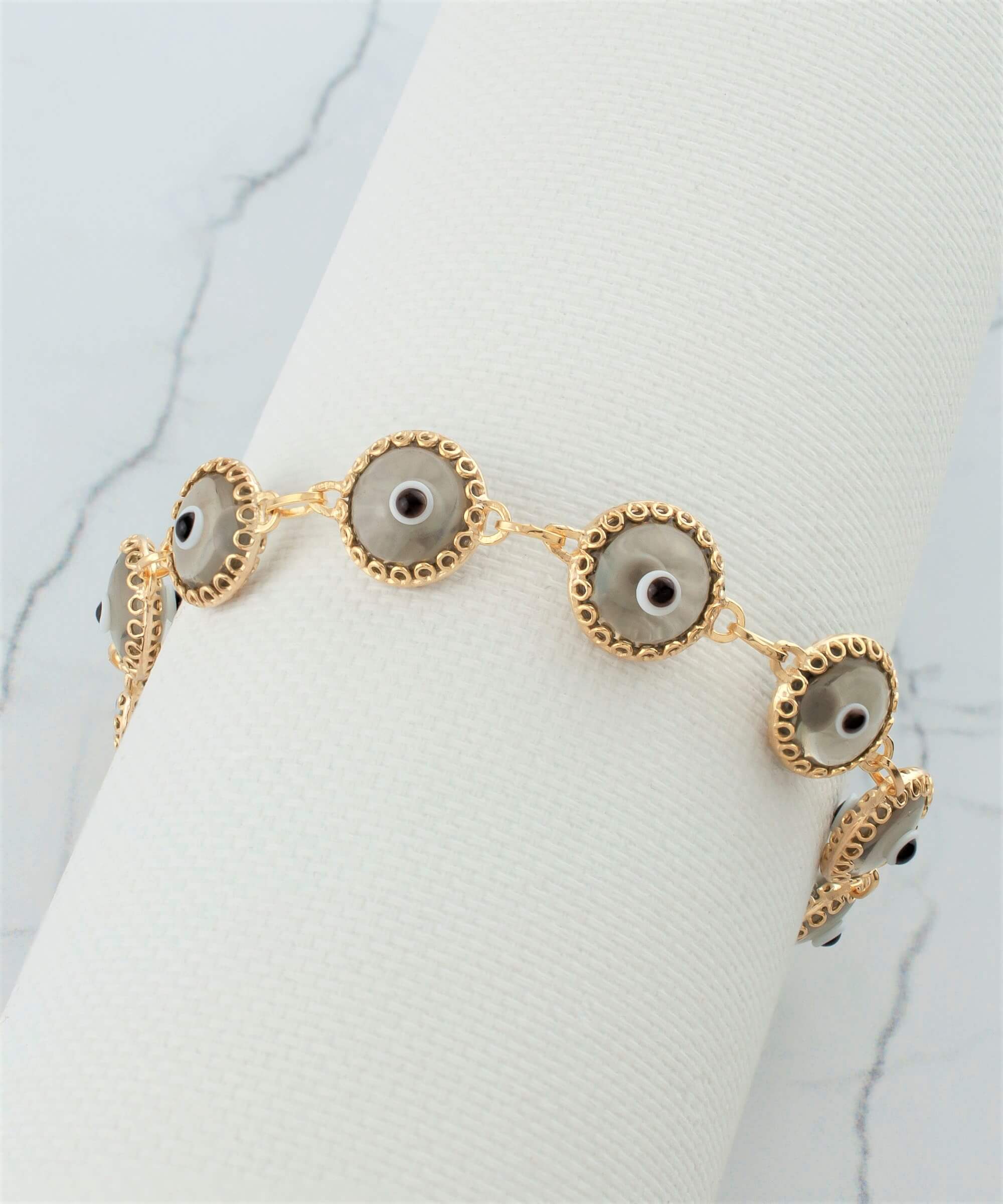 Elegant gold plated sterling silver link bracelet featuring 10 smokey evil eye beads, designed for women with a lobster claw clasp.