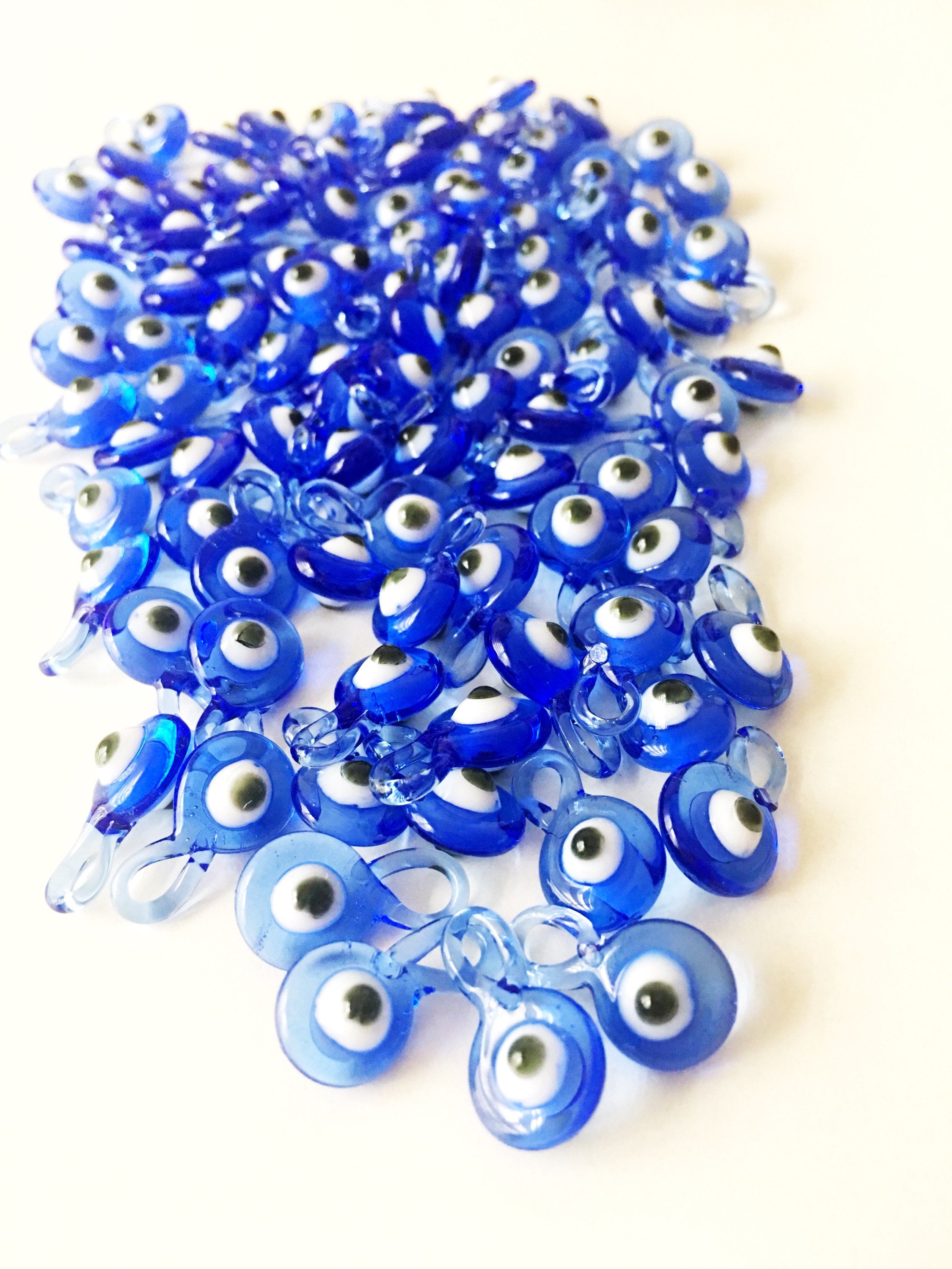 A collection of 10 blue glass evil eye charms, featuring intricate designs and metal hooks, perfect for baby shower favors.