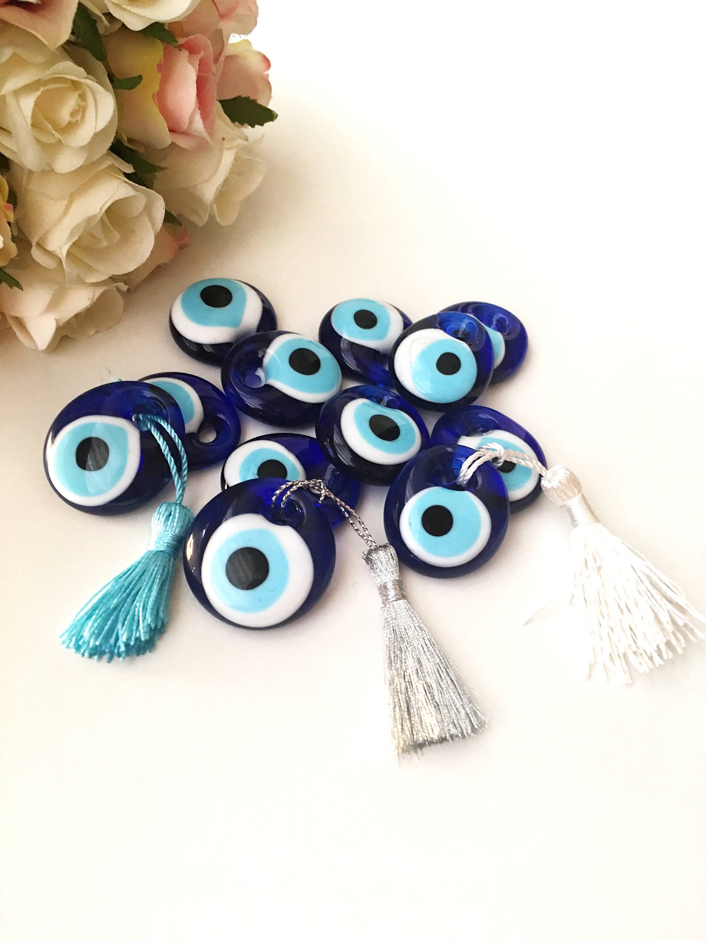 A collection of 100 blue evil eye beads made of glass, featuring blue ropes for hanging, symbolizing protection and good luck.