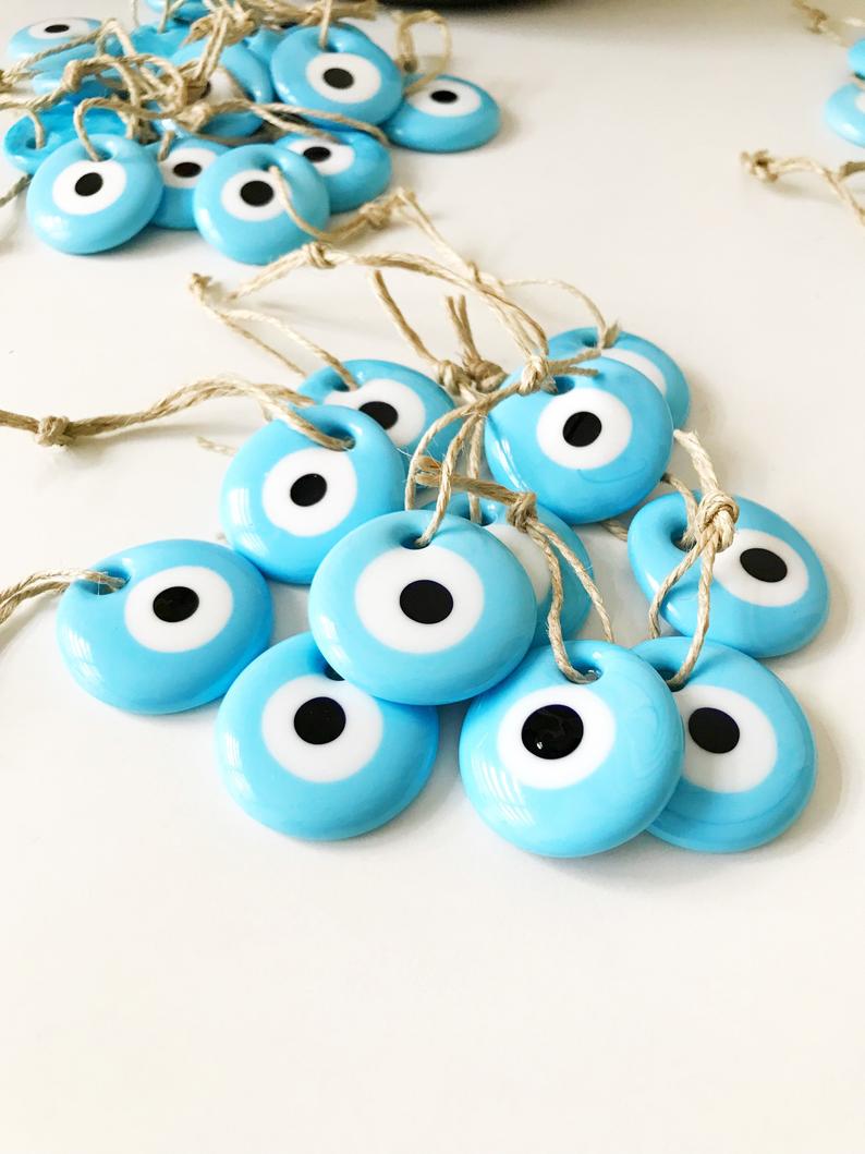 A collection of 100 blue glass evil eye beads, each 4.5 cm, with blue ropes for hanging, perfect as wedding favors.