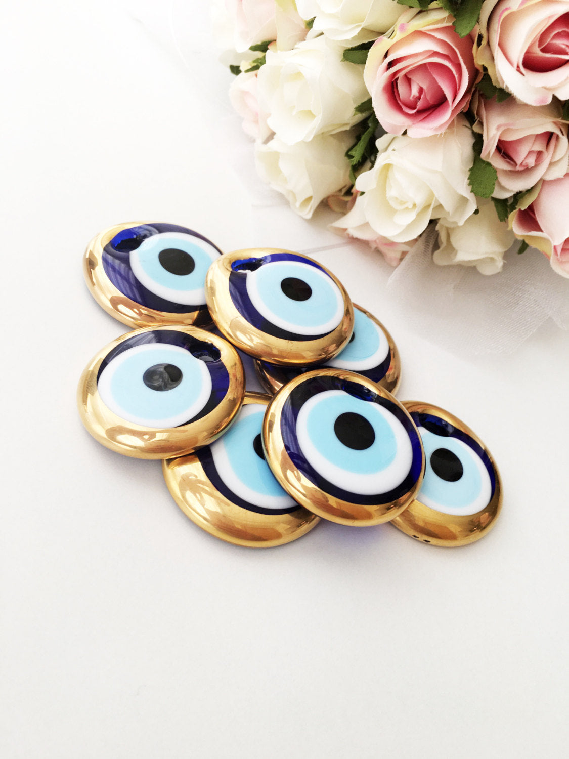 A set of 10 handmade evil eye charms featuring gold glass beads, ready for wall hanging or car decor, showcasing unique designs.