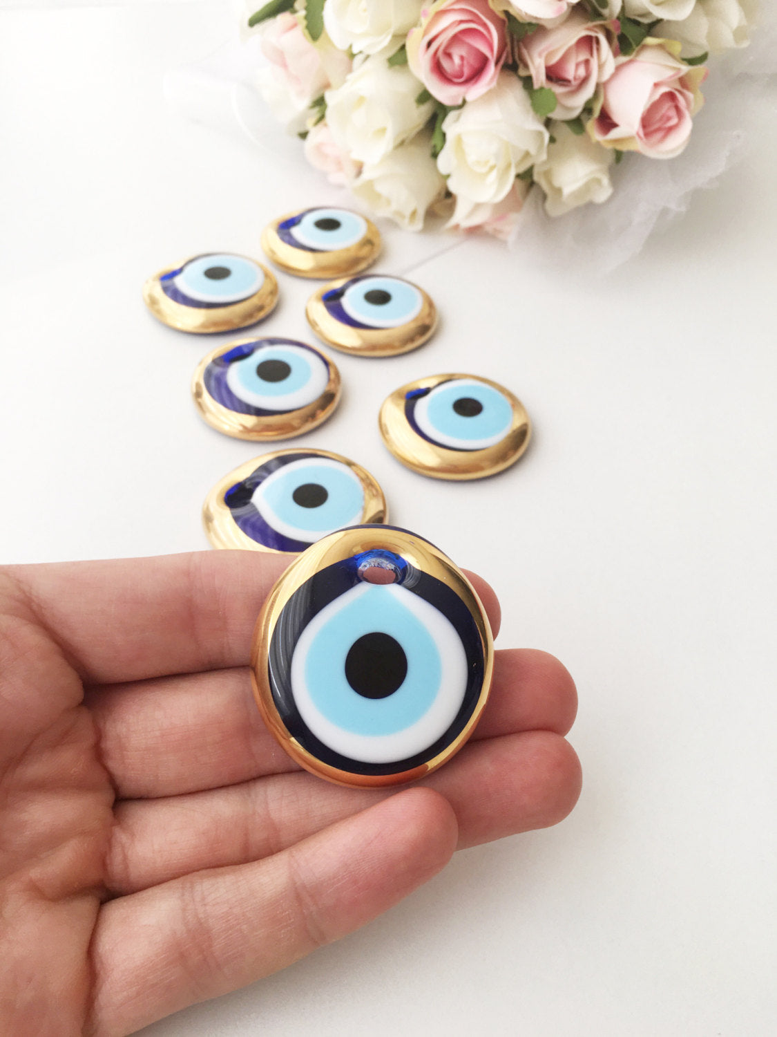 A set of 10 handmade evil eye charms featuring gold glass beads, ready for wall hanging or car decor, showcasing unique designs.