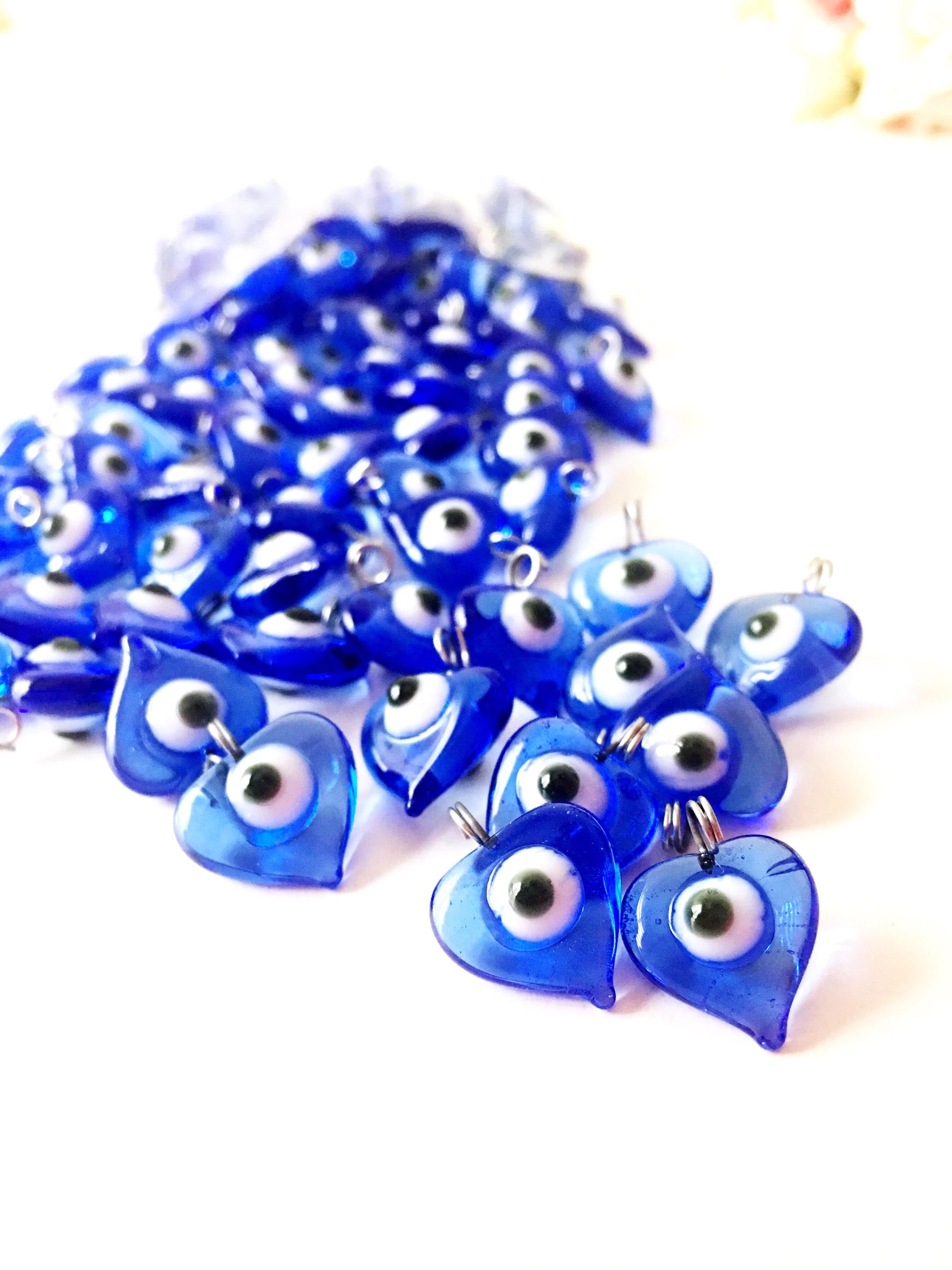 A collection of 100 unique blue evil eye charms with hooks, perfect for wedding favors and baby showers, displayed elegantly.