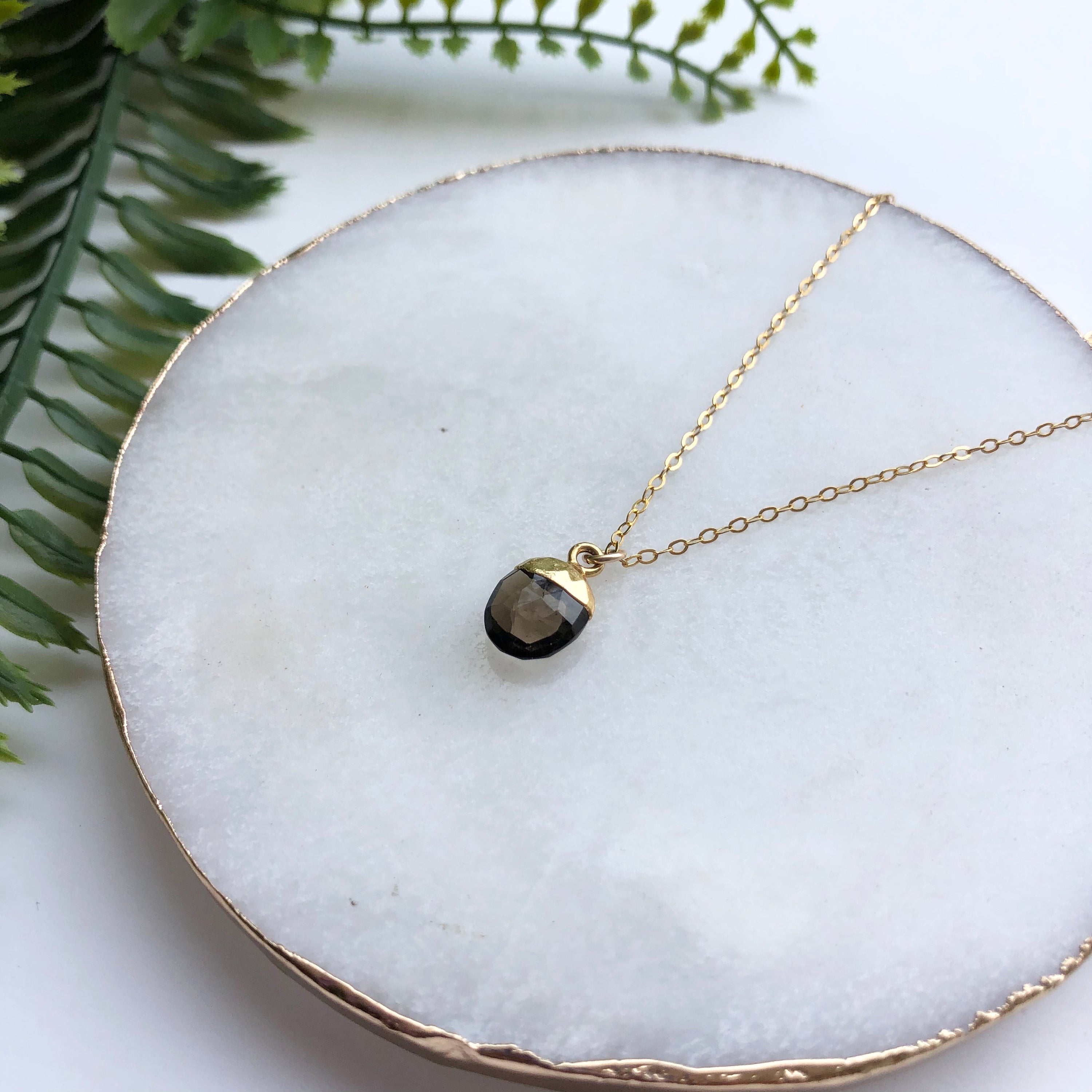 A delicate 14K gold filled necklace featuring a hand-cut Snow Pea pendant, elegantly displayed on a soft background.