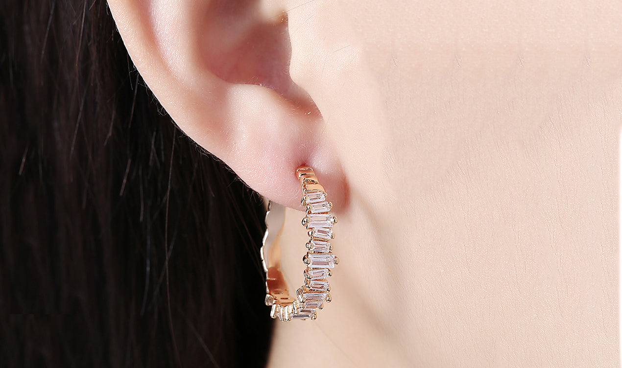 Elegant 14K gold plated earrings featuring emerald cut white sapphires, showcasing a unique asymmetrical design.