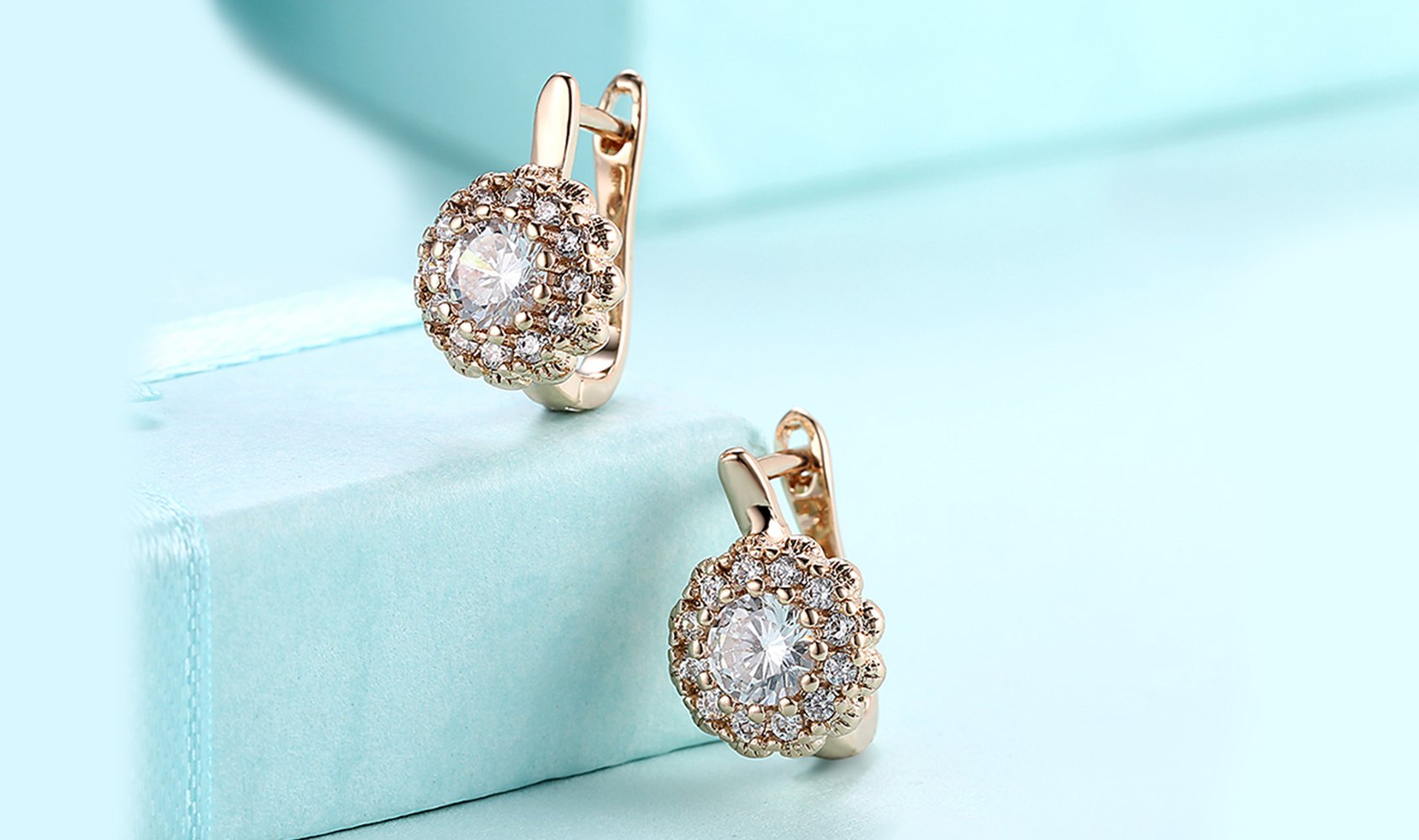 Elegant 14K gold plated huggie earrings featuring a floral design with white pav'e Austrian stones, perfect for any occasion.