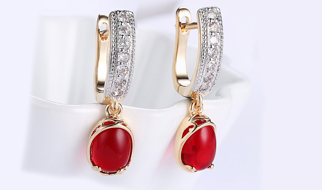 Elegant 14K gold plated clip-on earrings featuring red larimar stones, perfect for any occasion.