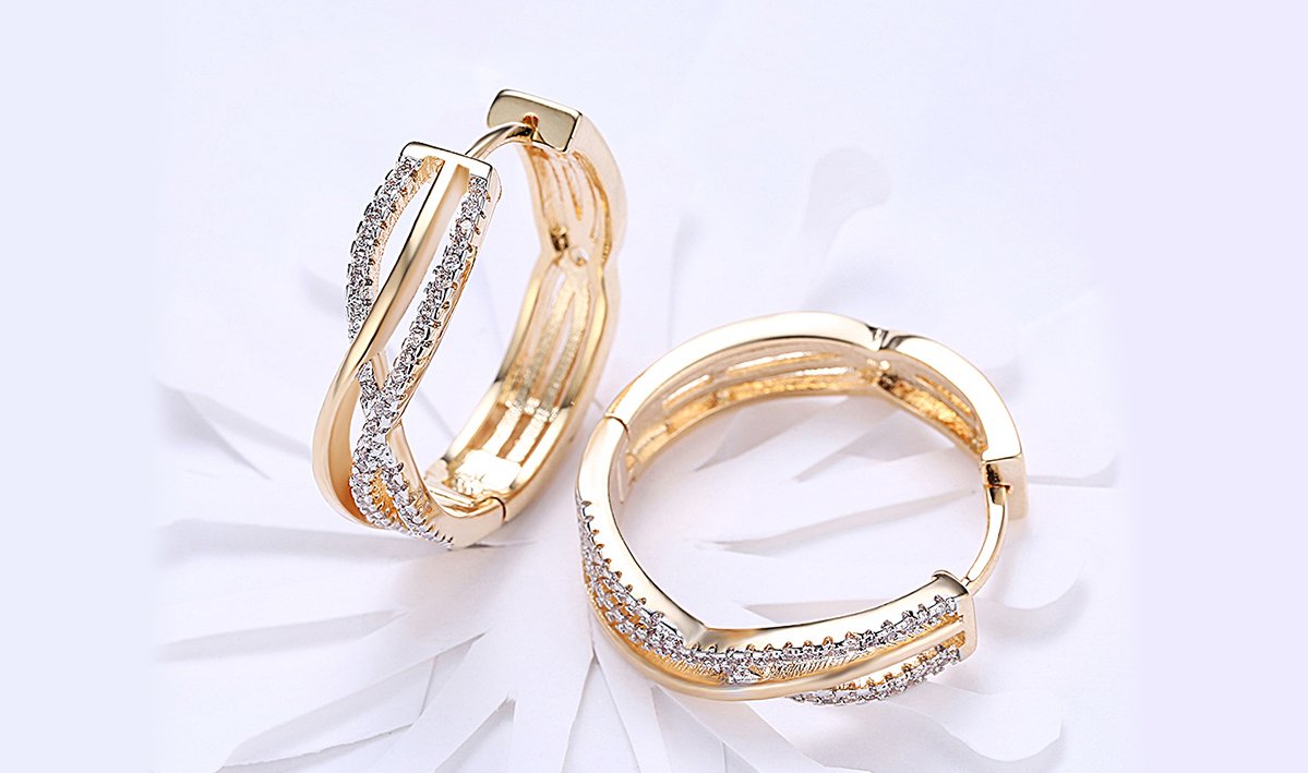 Elegant 14K gold plated clip-on earrings featuring white Austrian elements in a twisted abstract design.