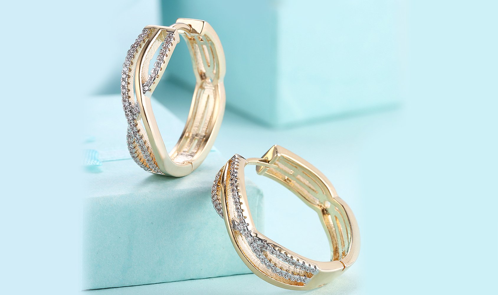 Elegant 14K gold plated clip-on earrings featuring white Austrian elements in a twisted abstract design.