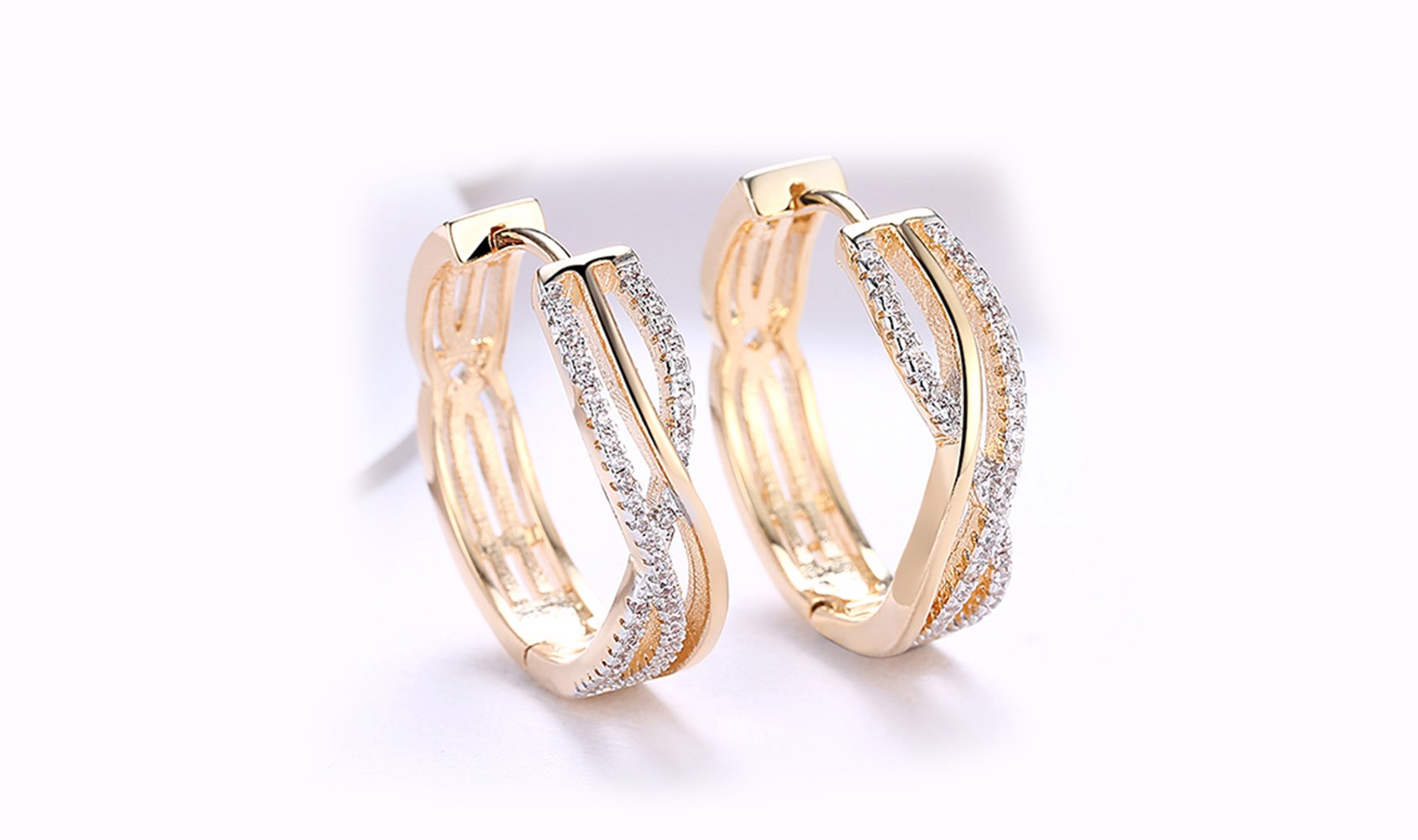 Elegant 14K gold plated clip-on earrings featuring white Austrian elements in a twisted abstract design.