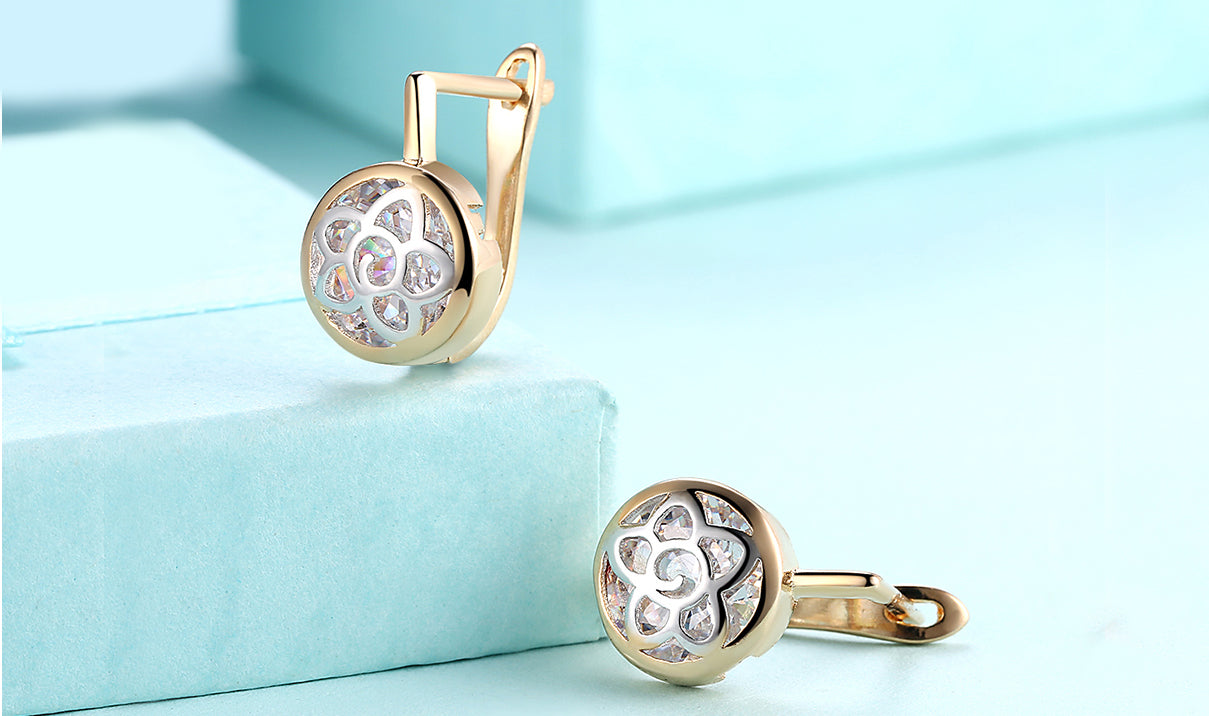 Elegant 14K gold plated circular clip-on earrings featuring a daisy design with white sapphire stones.