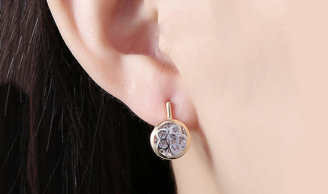 Elegant 14K gold plated circular clip-on earrings featuring a daisy design with white sapphire stones.