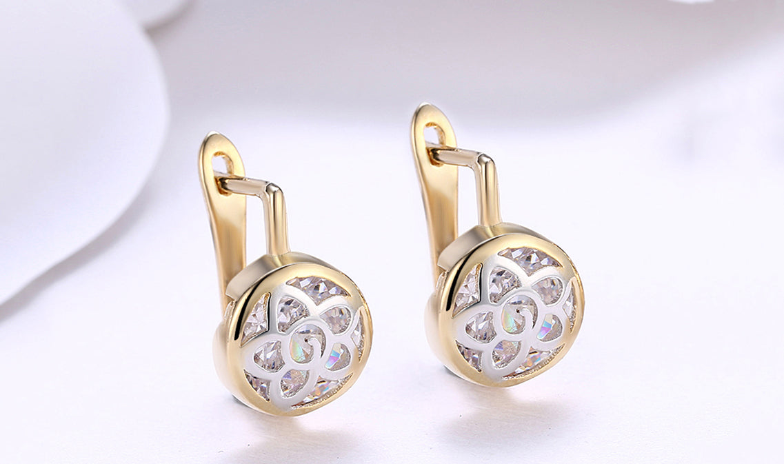 Elegant 14K gold plated circular clip-on earrings featuring a daisy design with white sapphire stones.