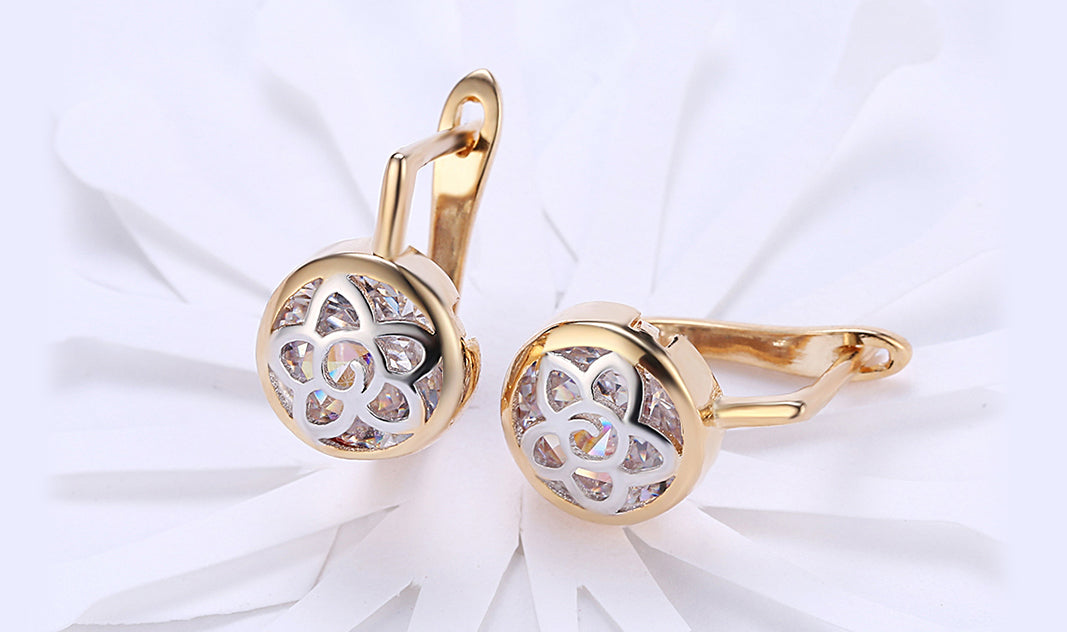 Elegant 14K gold plated circular clip-on earrings featuring a daisy design with white sapphire stones.