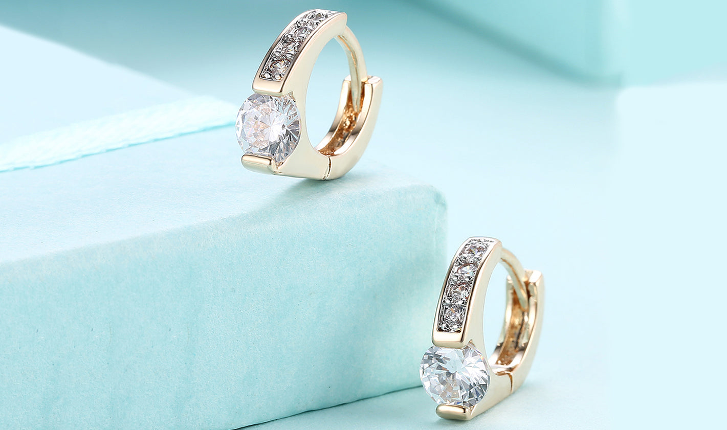 Elegant 14K gold plated clip-on earrings featuring white sapphire stones in a unique harp shape design.