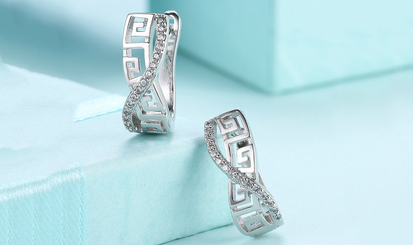 Elegant 14K white gold plated earrings featuring a Greek key design with sparkling Austrian elements.