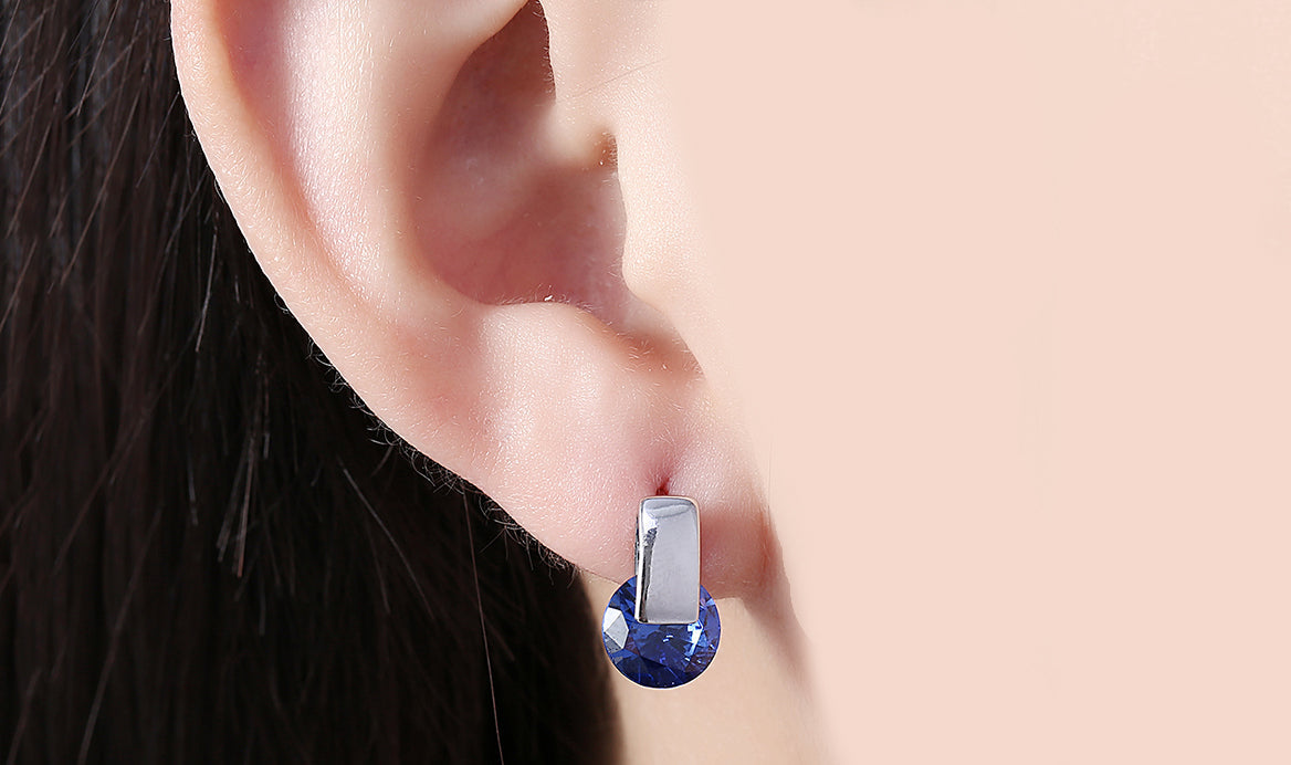 Elegant 14K white gold plated earrings featuring a stunning blue sapphire stone, perfect for any occasion.