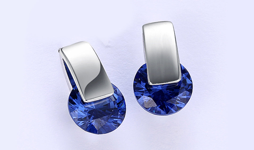 Elegant 14K white gold plated earrings featuring a stunning blue sapphire stone, perfect for any occasion.