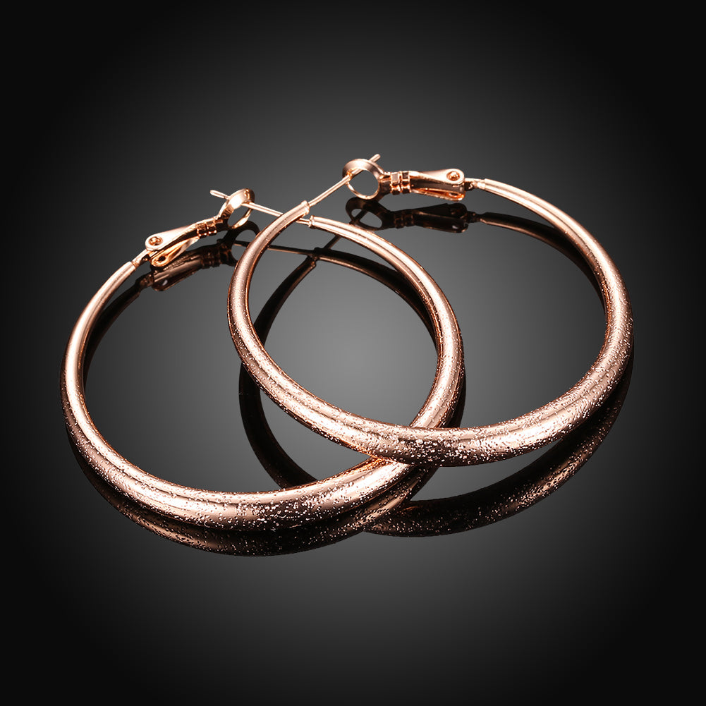 Elegant 1.6-inch round hoop earrings in 18K rose gold plating, showcasing a luxurious and timeless design.