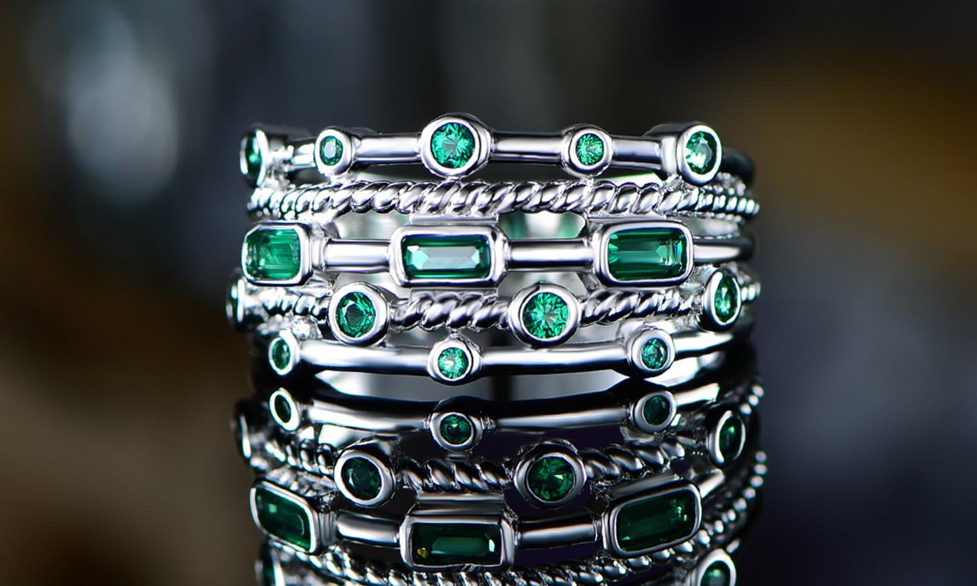 Elegant 18K white gold plated ring featuring five layers of round-cut lab-created green emerald stones.