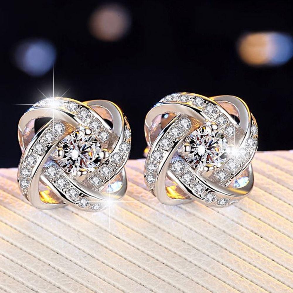 Elegant 18K white gold plated infinity twist stud earrings featuring sparkling Austrian crystals.