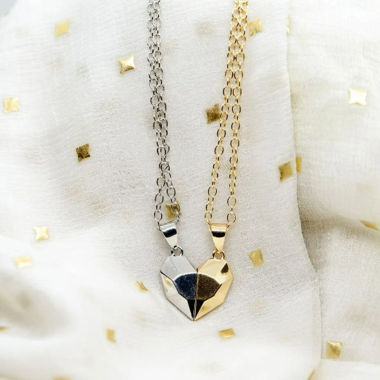 Two heart-shaped magnetic pendants on a minimalist chain, available in gold and silver, symbolizing love and connection.